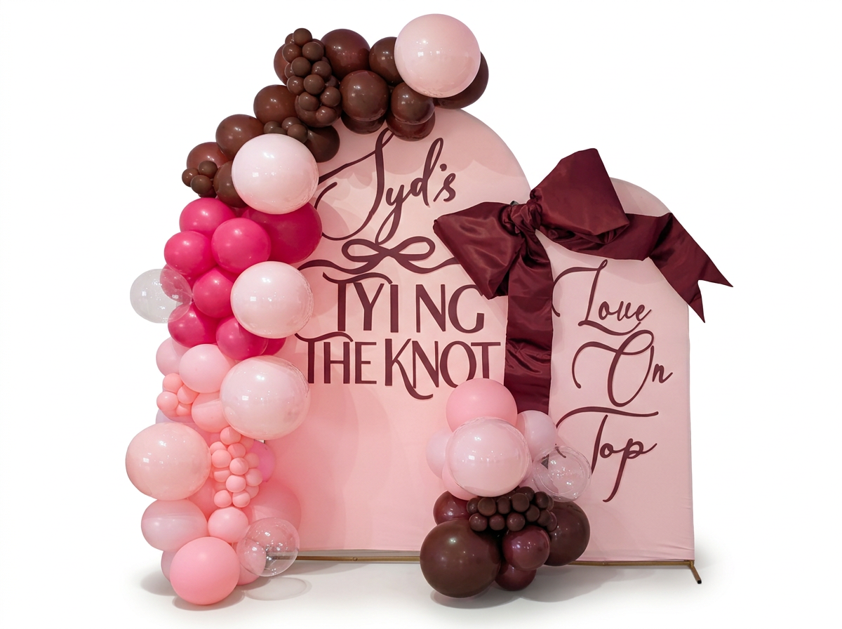 Pair of arch frame panels with a blush balloon garland and burgundy satin bow on a clean white background